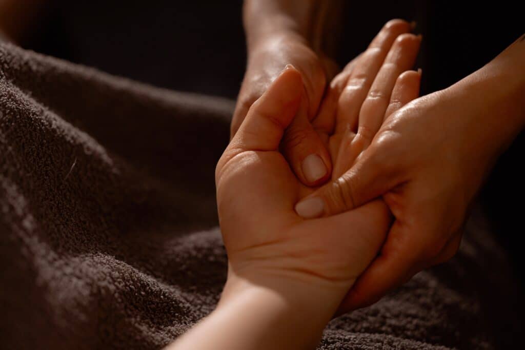 A therapist performing a wrist massage for carpal tunnel relief to reduce pain and improve flexibility