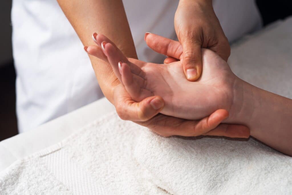 Massage therapy for arthritis in Grand Rapids helping a client with hand stiffness during Michigan’s cold months.