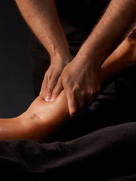 Close up of hands gently pressing the back of a client's leg.