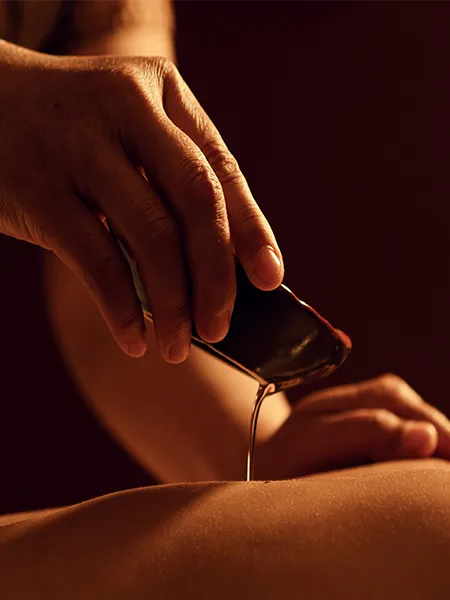 Essential oil being slowly dripped on a client's back.
