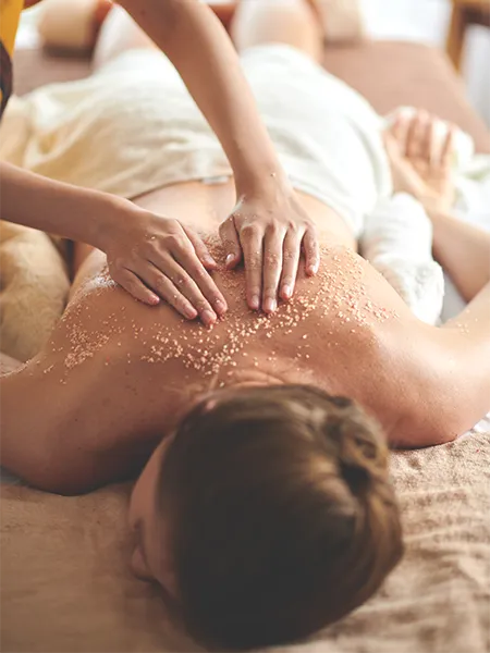 Woman with exfoliating salt scrub rubbed on her back.