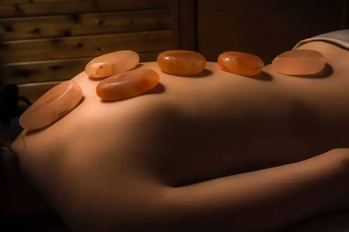 Himalayan hot stones resting gently on a comfortable woman's back.