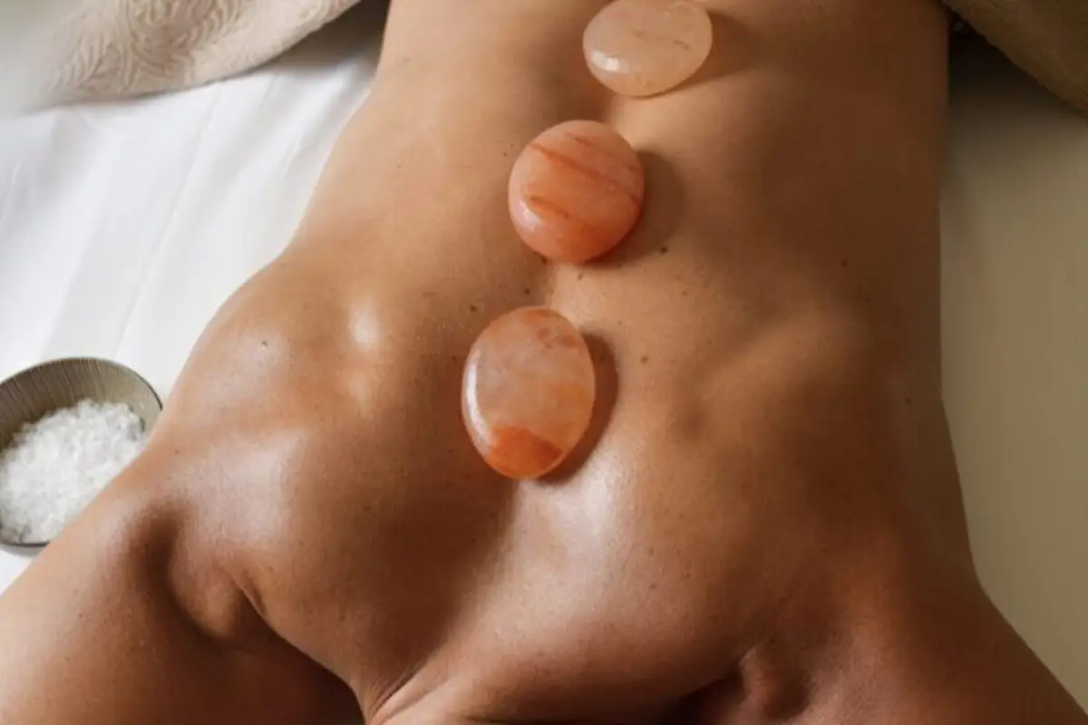 Himalayan hot stones resting gently on a man's muscular back.