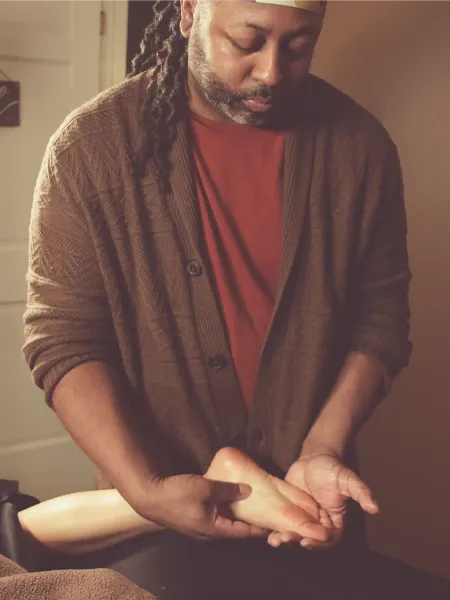 Johaun giving the mind, body, and sole massage to client's foot. 