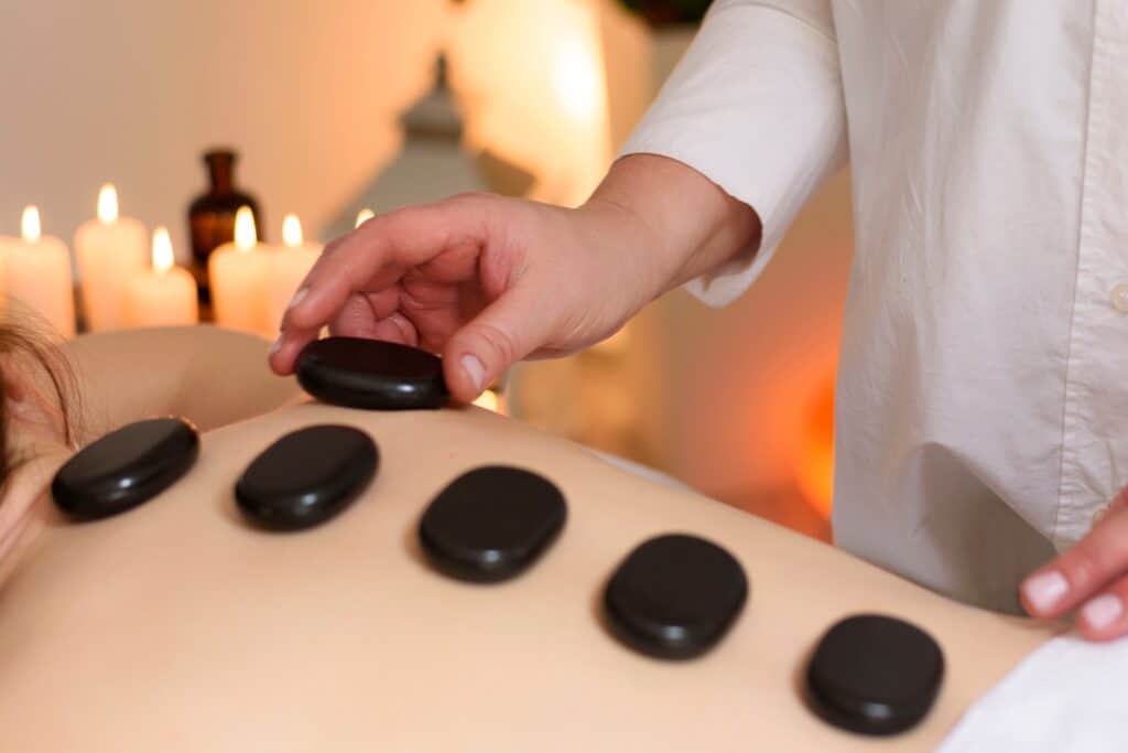 Massage therapist at Grand Rapids giving a hot stone massage to a new client.