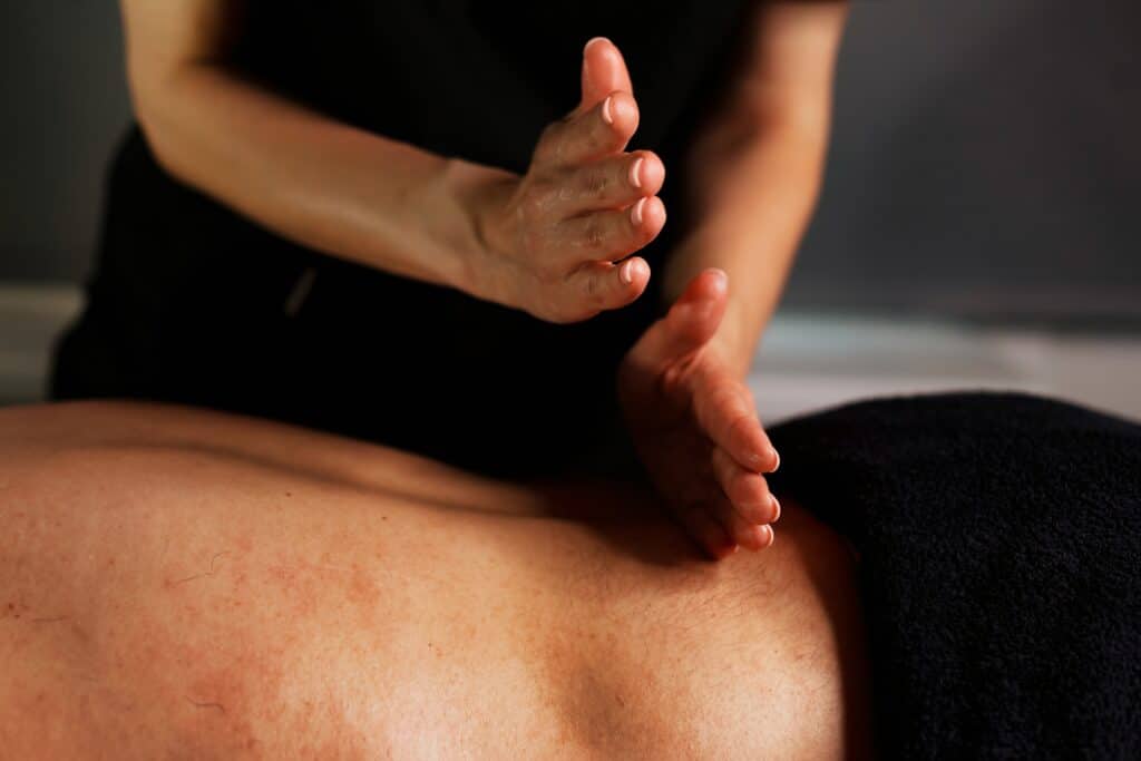 Massage therapist at Be Balanced Bodywork providing a therapeutic massage to support pain relief and long-term wellness.