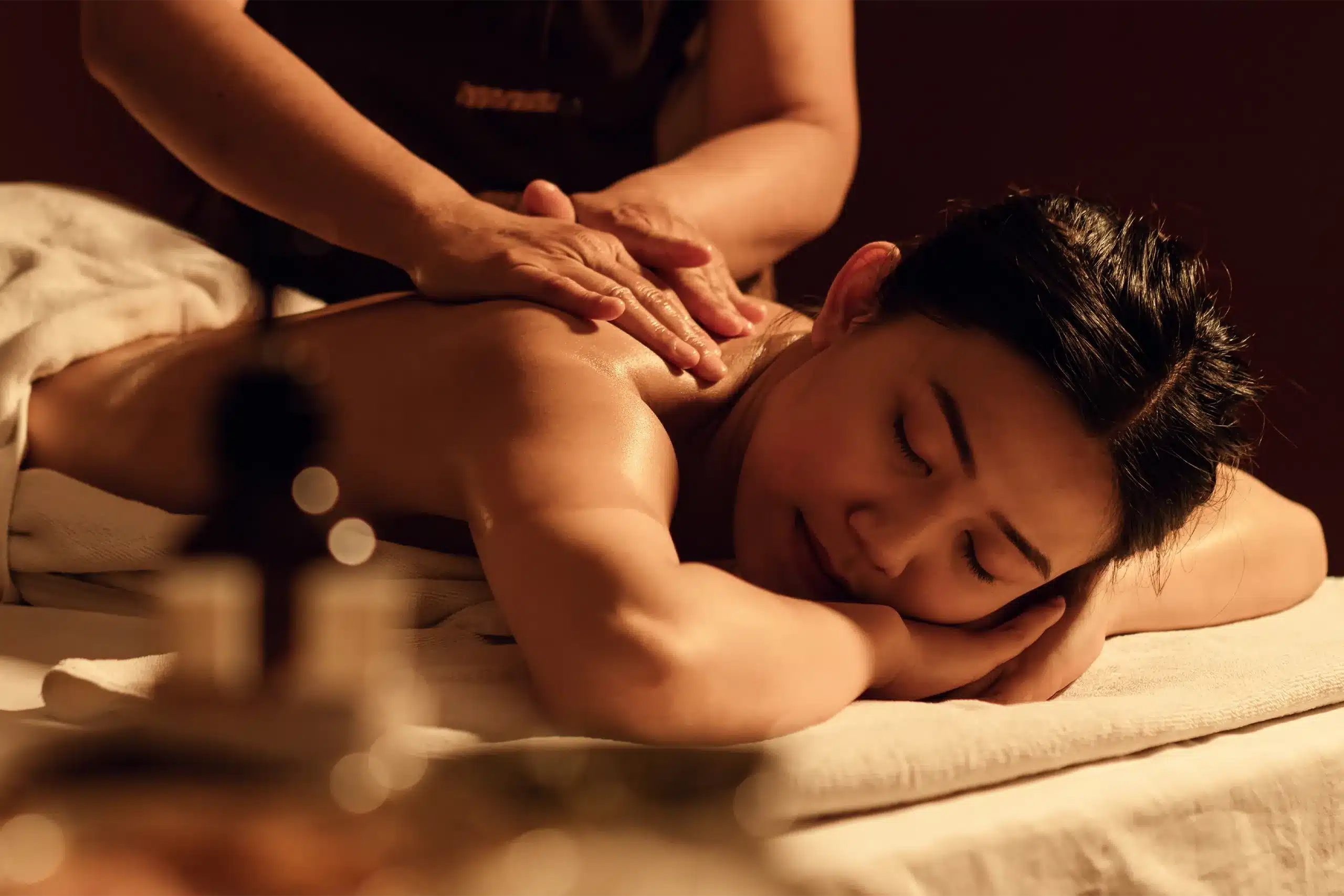 A relaxed woman receiving a head massage