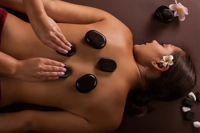 A woman relaxing with five hot stones on her back 