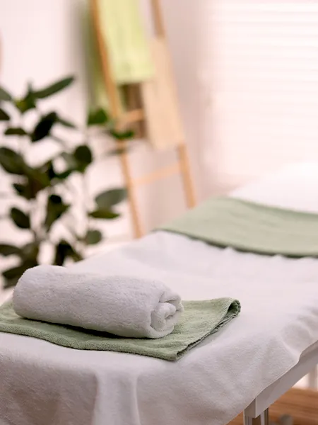 Rolled towel on massage table in spa center.