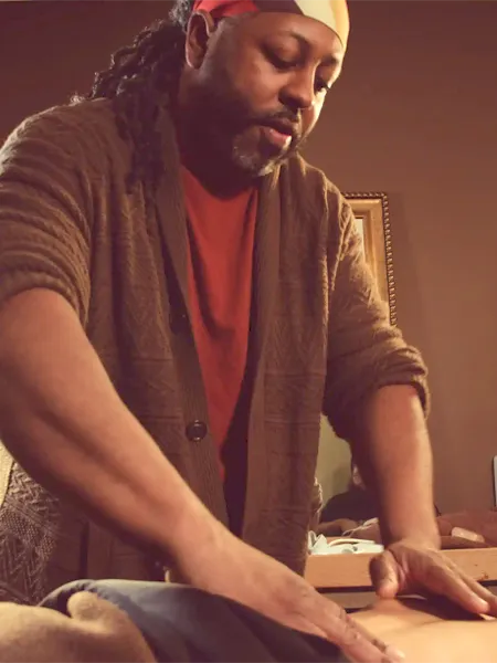 Johaun applying deep tissue pressure on the client's back.