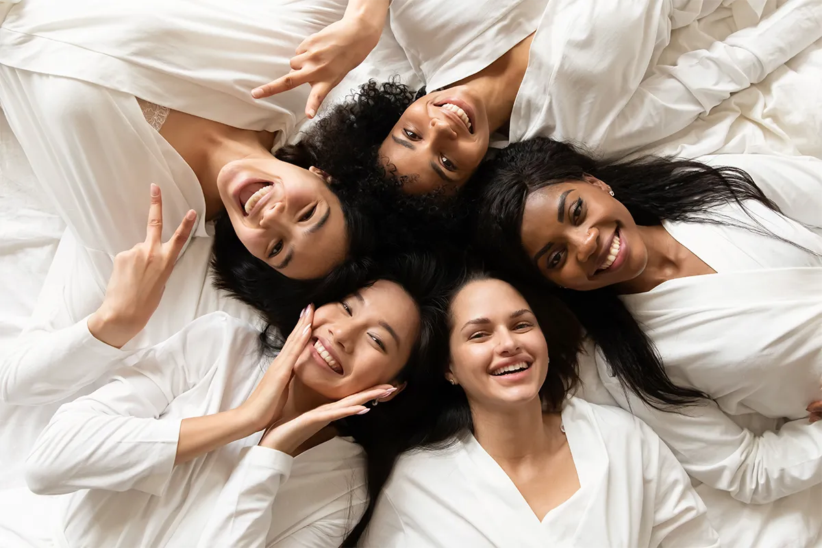 A group of women dressed in spa robes laughing and having a good time.