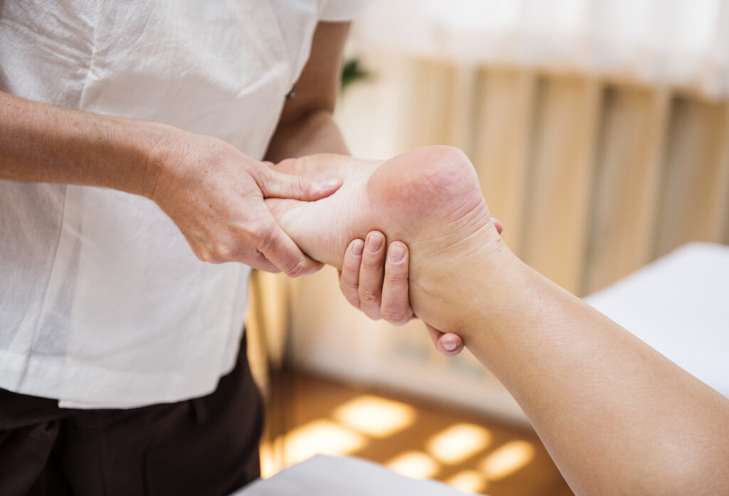 Massage therapist working on the calf and bottom of the foot to relieve tension associated with plantar fasciitis.