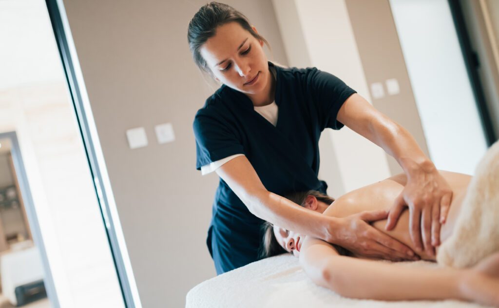 Massage therapist providing therapeutic massage to help a client manage muscle tension and ongoing pain.