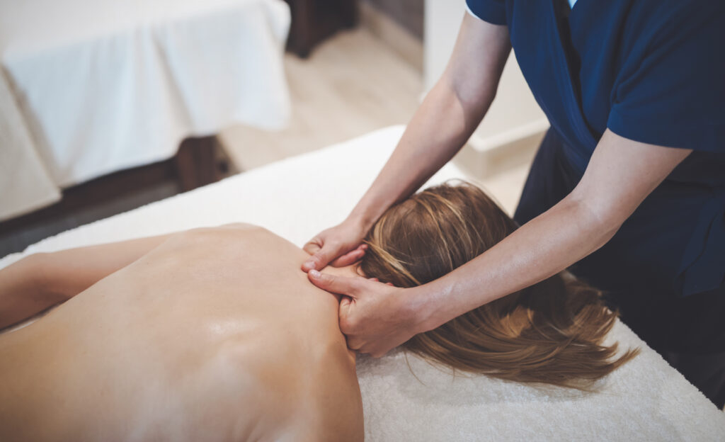 Massage therapist relieving neck, shoulder, and upper back tension to support healthier posture and comfortable movement.