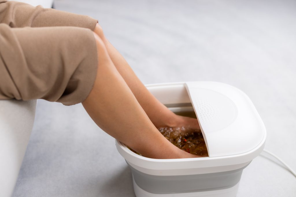 Client relaxing during an ionic detox foot soak at Be Balanced Bodywork in Grand Rapids.