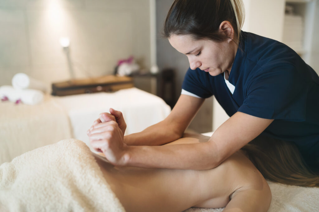 Massage therapist using gentle therapeutic techniques to relieve surrounding muscle tension for a client experiencing nerve sensitivity.