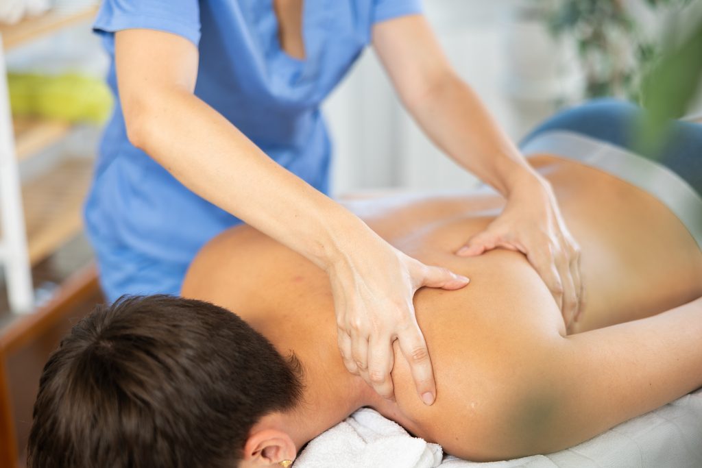 Massage therapist providing therapeutic massage for recurring muscle tension and common pain patterns.